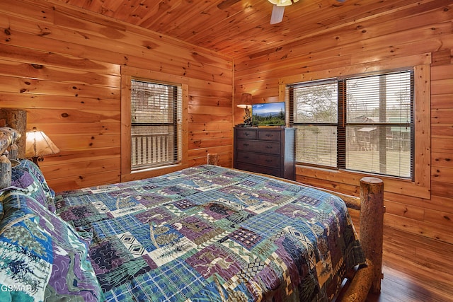 bedroom with wooden ceiling, wood walls, and wood finished floors