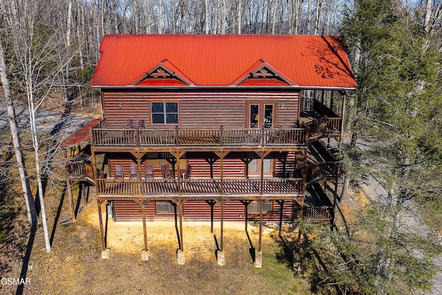 back of property featuring french doors, a wooden deck, metal roof, and log veneer siding