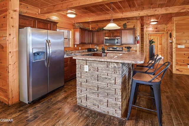 kitchen featuring beam ceiling, wooden walls, wooden ceiling, dark wood finished floors, and appliances with stainless steel finishes
