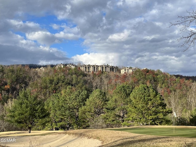 exterior space with view of golf course and a view of trees