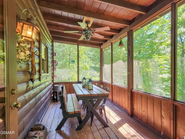 unfurnished sunroom featuring beam ceiling, ceiling fan, and wood ceiling