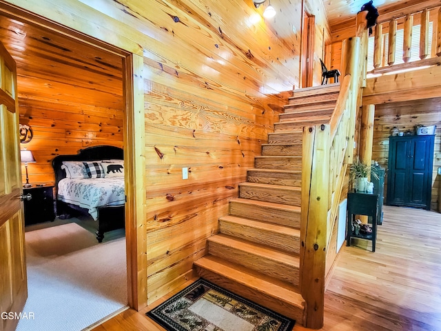 stairs featuring wood walls and wood-type flooring