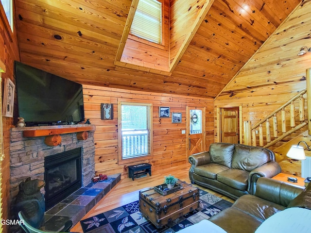 living room featuring a fireplace, wood ceiling, and wood walls