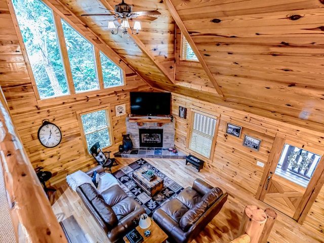 living room with ceiling fan, wooden ceiling, beamed ceiling, high vaulted ceiling, and a fireplace