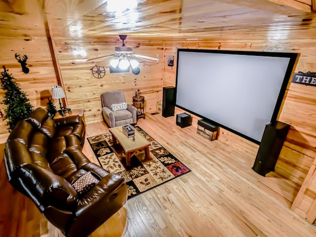 cinema with hardwood / wood-style flooring, ceiling fan, and wooden walls