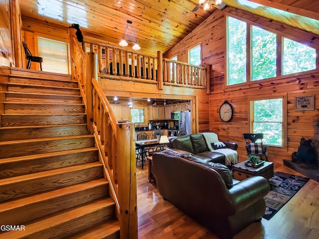 living room with wooden walls, high vaulted ceiling, wooden ceiling, and hardwood / wood-style flooring