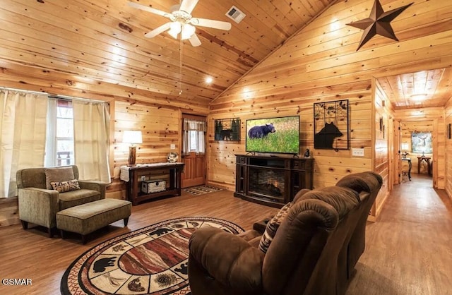 living room featuring a fireplace, a ceiling fan, wood finished floors, and visible vents