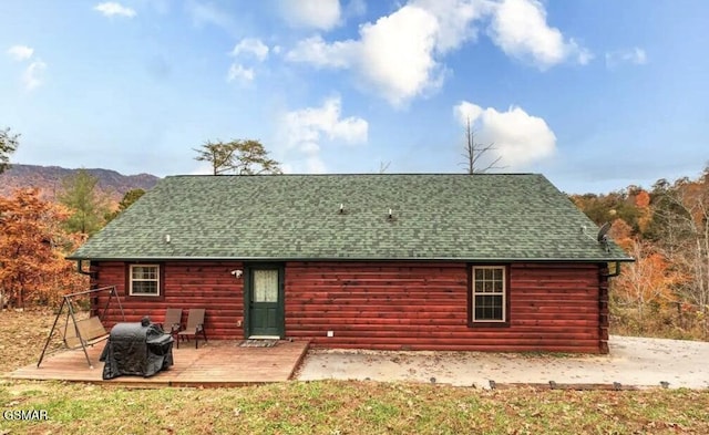 back of property featuring a wooden deck and a shingled roof