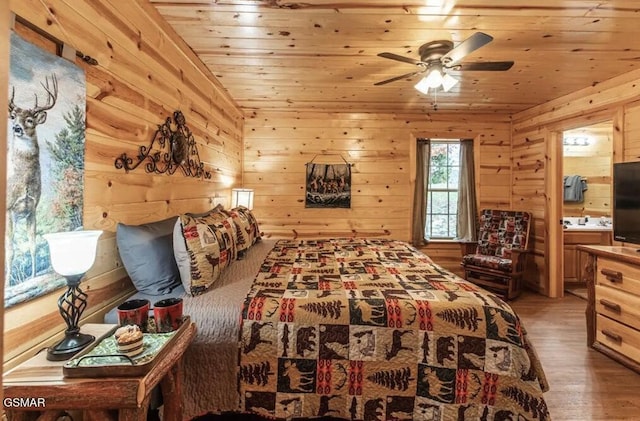 bedroom with wood ceiling, wood walls, light wood-style flooring, and ensuite bathroom