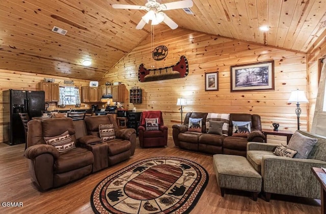 living room featuring wooden walls, ceiling fan, wooden ceiling, wood finished floors, and lofted ceiling