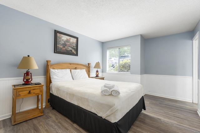 bedroom featuring dark hardwood / wood-style flooring and a textured ceiling