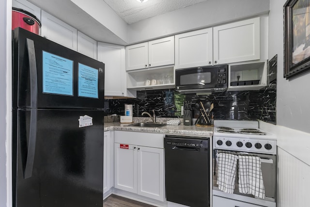 kitchen with black appliances, white cabinetry, sink, and tasteful backsplash