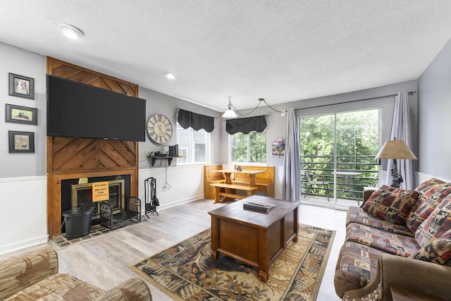 living room with light hardwood / wood-style floors and a textured ceiling