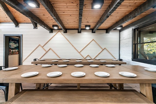 unfurnished dining area featuring beam ceiling, wooden walls, and wood ceiling