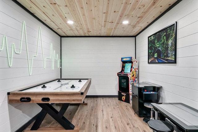 rec room featuring wood walls, light hardwood / wood-style flooring, and wooden ceiling