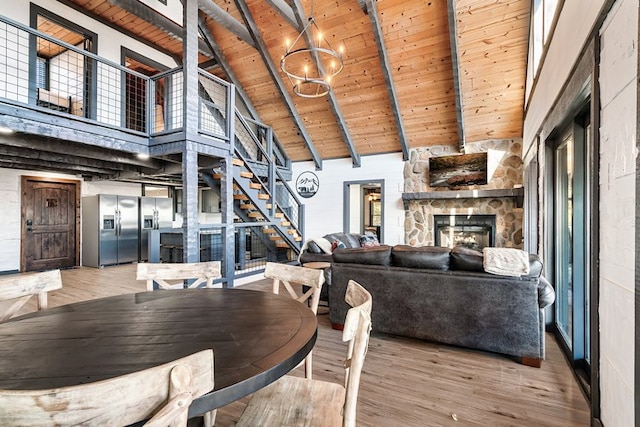 dining area featuring beam ceiling, a fireplace, high vaulted ceiling, and wooden ceiling