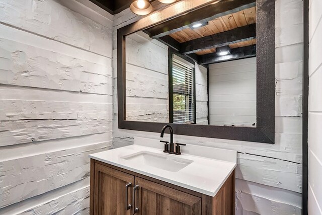 bathroom featuring wood walls, vanity, and wood ceiling