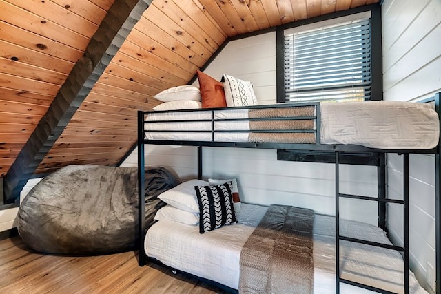 bedroom featuring hardwood / wood-style floors, vaulted ceiling, wooden ceiling, and wood walls