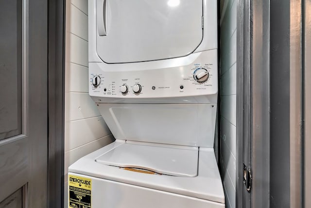 clothes washing area featuring stacked washing maching and dryer