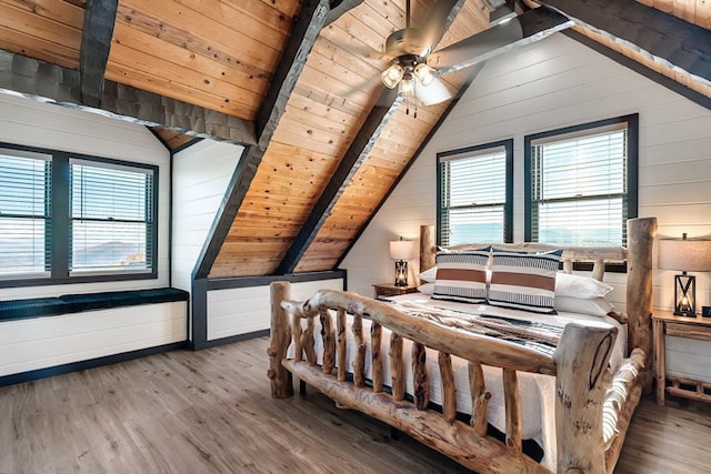 bedroom with vaulted ceiling with beams, wooden walls, wood ceiling, and wood-type flooring