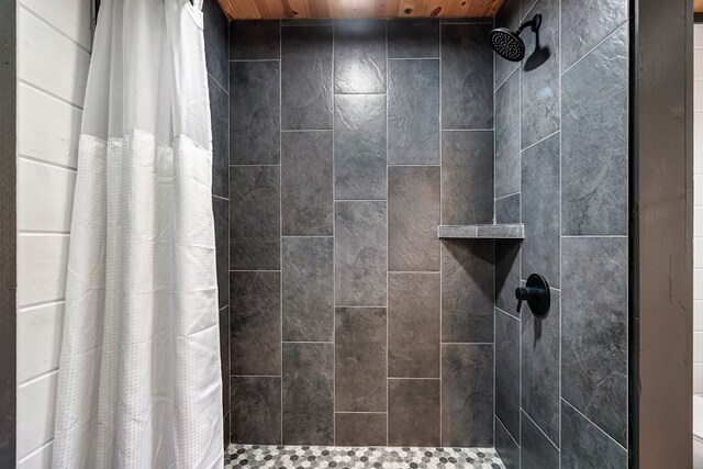 bathroom featuring wood ceiling and walk in shower