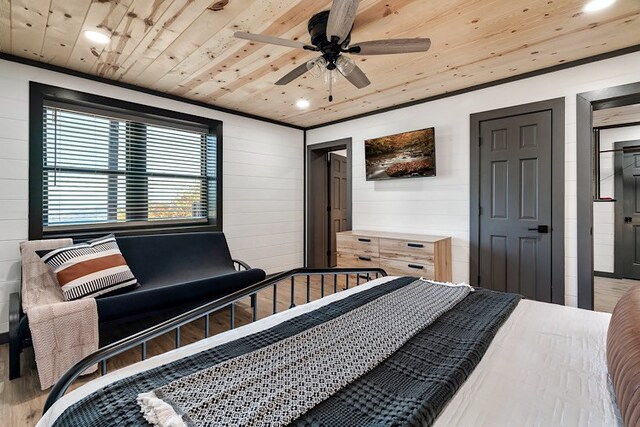 bedroom with ceiling fan, wood ceiling, crown molding, and wooden walls