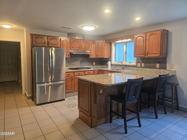 2257 Shinbone Rd, Sevierville, TN 37876 - kitchen featuring stainless steel appliances, a peninsula, under cabinet range hood, a sink, and tasteful backsplash