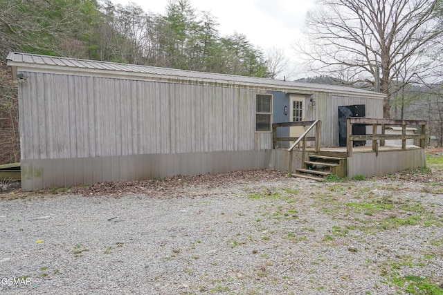 back of property featuring a wooden deck and metal roof