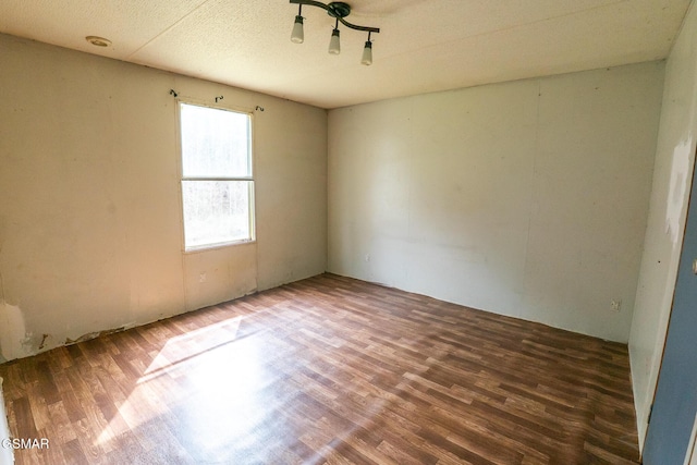 spare room featuring a textured ceiling and wood finished floors