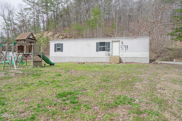 view of front facade with entry steps, a front yard, and a playground