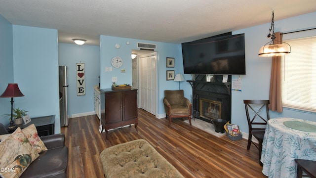 living room with dark hardwood / wood-style floors and a textured ceiling