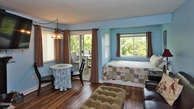 bedroom with a chandelier, a textured ceiling, access to outside, and dark wood-type flooring