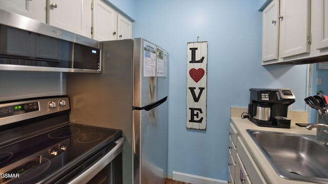 kitchen with white cabinetry, sink, and stainless steel appliances