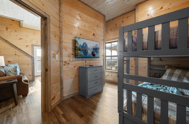 bedroom featuring wooden walls, wooden ceiling, and wood finished floors