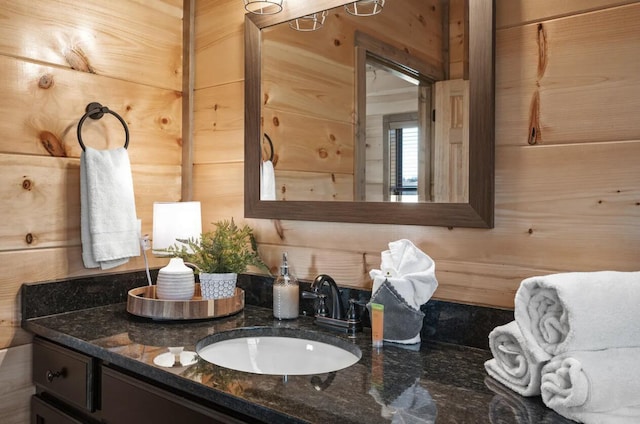 bathroom featuring vanity and wood walls