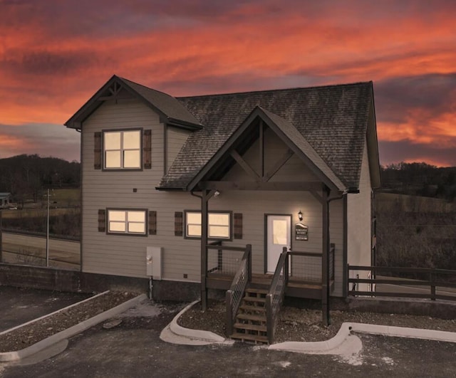 view of front of home with covered porch and a shingled roof