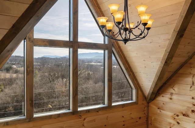 interior space featuring a mountain view, wooden walls, an inviting chandelier, wood ceiling, and vaulted ceiling with beams