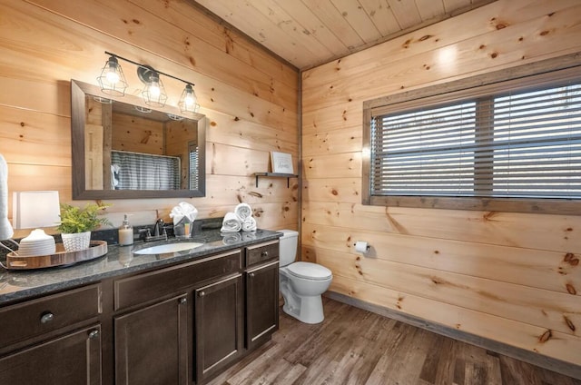 bathroom with wood walls, toilet, wooden ceiling, wood finished floors, and vanity