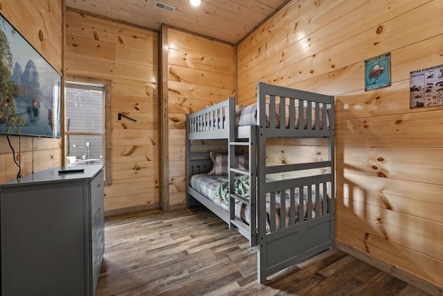 bedroom with wooden walls and wood finished floors