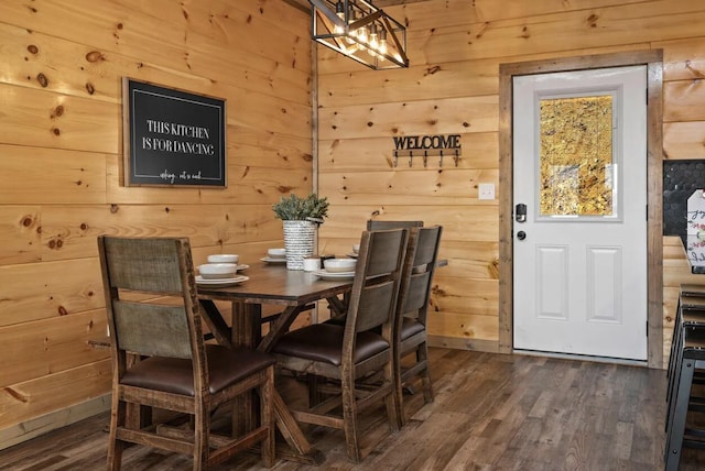 dining area with dark wood-style floors and wood walls