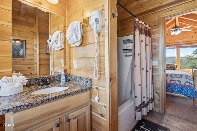 full bathroom with wood walls, shower / bath combo, connected bathroom, and vanity