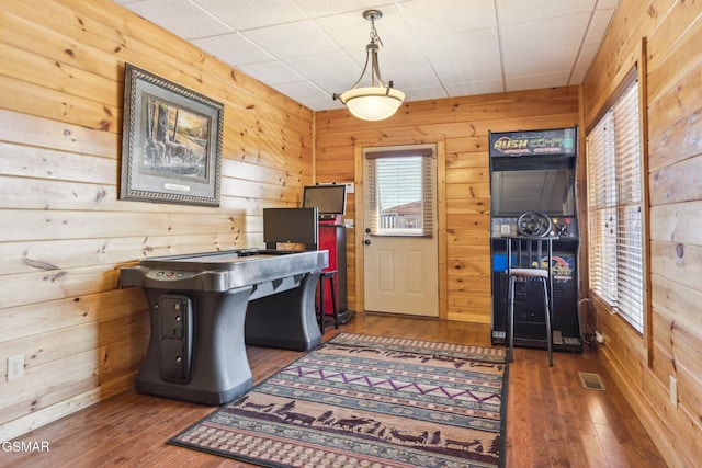 home office featuring visible vents, wood walls, and hardwood / wood-style flooring