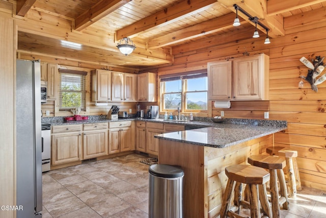 kitchen featuring freestanding refrigerator, wood ceiling, wood walls, and a peninsula