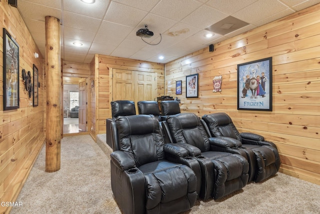 carpeted home theater featuring wood walls