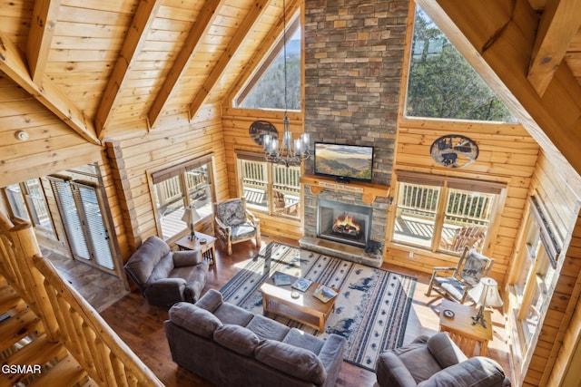 living room featuring wooden walls, wooden ceiling, a stone fireplace, high vaulted ceiling, and beam ceiling