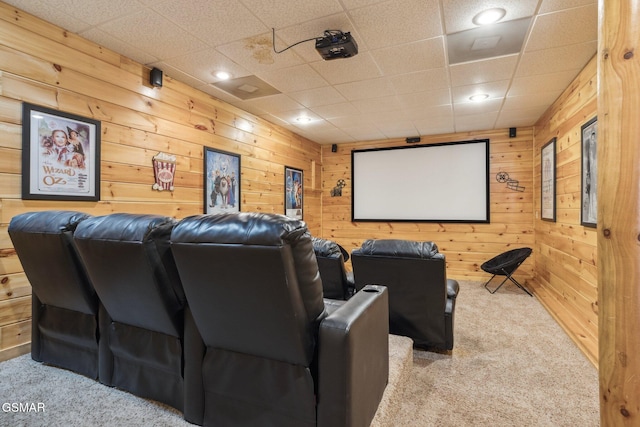 carpeted cinema room with wooden walls and recessed lighting