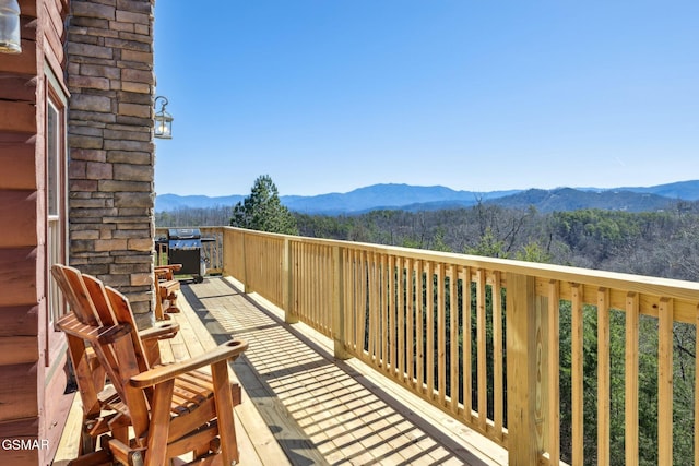 balcony with a grill, a mountain view, and a view of trees