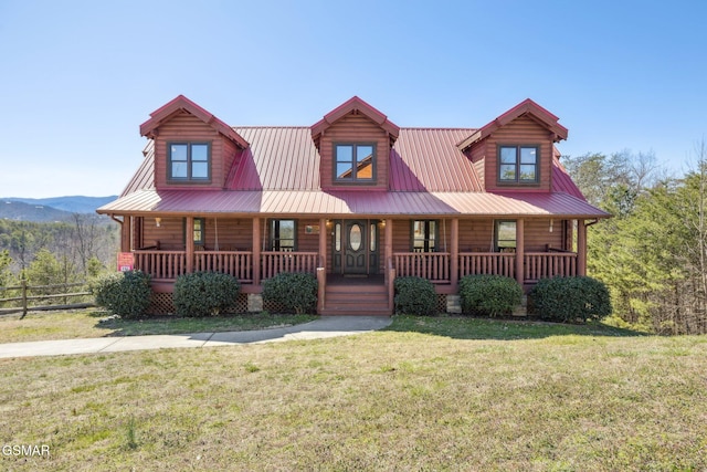 view of front facade featuring metal roof, fence, a front lawn, and a porch