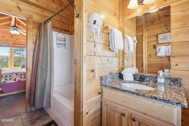 bathroom featuring tile patterned flooring, shower / bath combination with curtain, vanity, and wooden walls