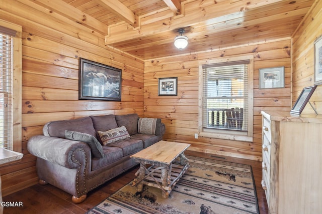 living area with dark wood-type flooring, wooden ceiling, beamed ceiling, and wood walls